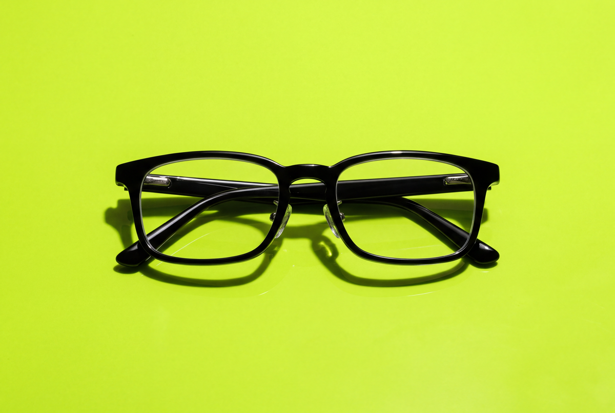 Front view of a black acetate optical frame with keyhole bridge, nose pads and metal hinges